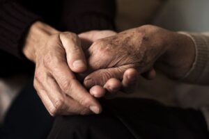 sepia-colored image of two hands holding another